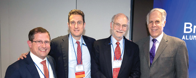 Michael Rosbash, wearing a suit, posing with three other men in suits.